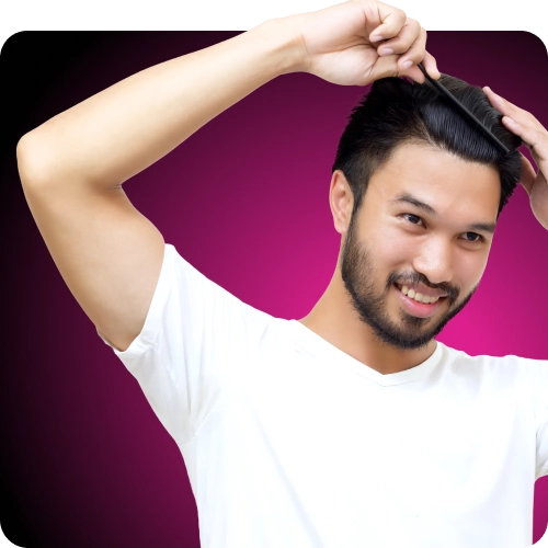 Asian man smiling and combing his hair